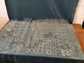 A suite of cut ribbed glassware including bowls, several sizes of drinking glasses, cups, all in