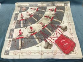 J Abadie, a Hermès silk scarf titled Cliquetis, printed with two rows of red and white sword