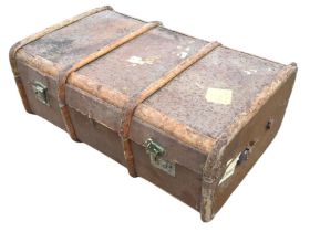 A travel trunk with brass mounts and rounded wood slats on canvas lined ground. (34.5in x 21.25in
