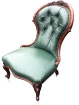 A Victorian mahogany leather button upholstered spoonback chair with foliate scrolled carving and