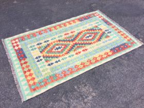 A Turkish kilim, the multicoloured field with two zigzag lozenge medallions within conforming