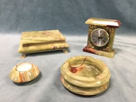 A Brazilian onyx smokers set, with a cigarette box on paw feet, a candle holder, and a circular