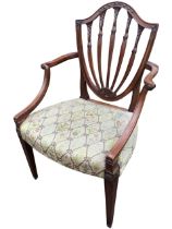 A Hepplewhite style mahogany open armchair with carved shield shaped back above scrolled arms with