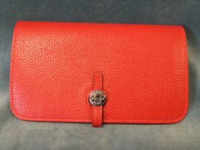 A red leather Hermès wallet and detachable purse, with two main pockets and a folding strap