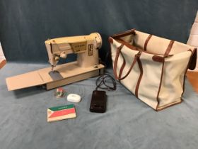 A portable Singer electric sewing machine, model 317, with carrying case and manual.