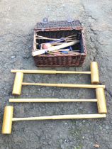 A croquet set in later M&S basket,containing hoops, balls and coloured post, with four oak