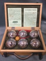 A Jonelle Jaques boxed set of chromed cast steel boules and a wood jack, complete with rules