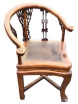 An antique shaped elm and rosewood corner chair, the horseshoe back and arms above carved pierced