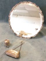 A circular continental silver easel mirror, the bevelled plate within an embossed scrolled frame