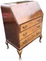 A Georgian style mahogany bureau, the rounded top with slant front opening on lopers to a fitted