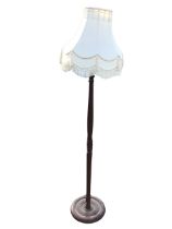 A mahogany standard lamp, the tasselled shade on a turned column with circular base. (65in)