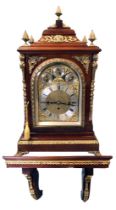 A large Edwardian mahogany bracket clock, the moulded top with pineapple finials above an arched