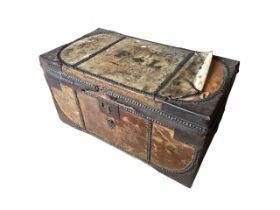 An early nineteenth century skin covered trunk with brass studding and iron mounts with brass