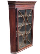 A Georgian mahogany corner cabinet, the dentil cornice above a satinwood strung astragal glazed door