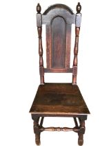 An eighteenth century oak wainscot chair with arched panelled back framed by turned columns with