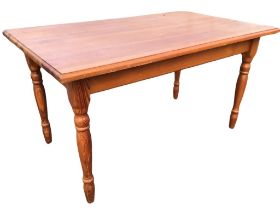 A Victorian style pine kitchen table, the rectangular top above moulded aprons, raised on turned