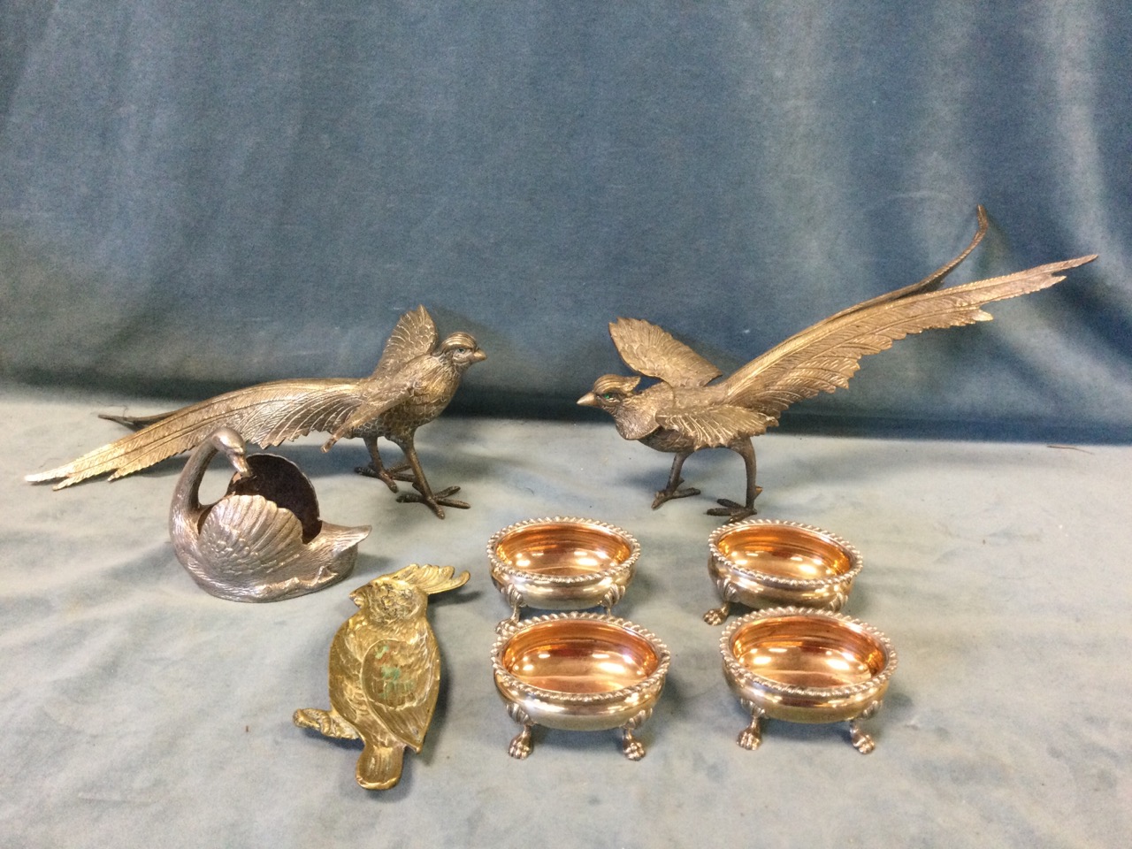 A set of four Victorian oval silver plated salts with gadrooned rims on paw feet; a pair of pheasant