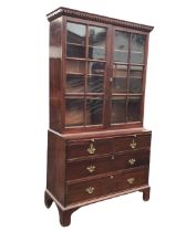 A George III mahogany bookcase on chest, with dentil cornice above a pair of astragal glazed doors