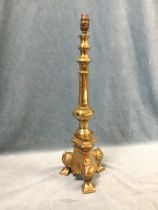 A large brass tablelamp of hexagonal column form raised above a triangular base with scrolled