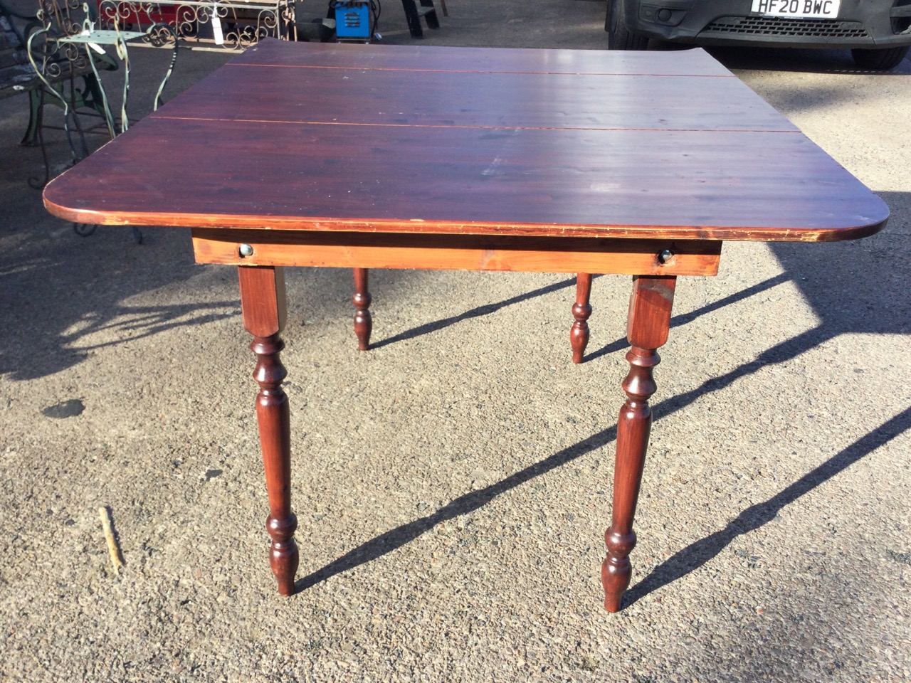 A stained pine dining table, the shaped top raised on turned tapering legs. (44in x 54.5in x 30. - Image 2 of 3