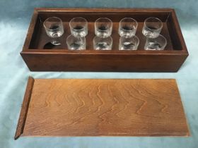 A cased set of nine tot glasses, each hand-engraved with a different game bird or animal, the fitted