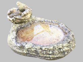 A composition stone birdbath with naturalistically moulded oval pool mounted with cupped hands and