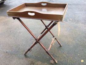 A mahogany butlers tray on stand, the rectangular platform with raised sides and pierced handles