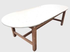 A contemporary rectangular pine table with rounded ends, the painted top on square column legs