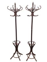 A pair of bentwood coatstands, each with six scrolled hooks around a turned column with ribbed