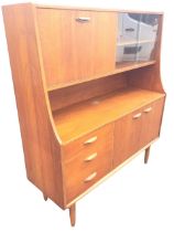 A mid-century teak wall unit, the top with sliding glass doors and drop-down compartment above an