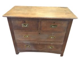 An oak chest of drawers with rectangular top above two short and two long drawers mounted with brass