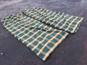 A pair of lined curtains woven in a green and yellow tartan pattern, rufflette gathered with