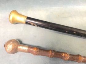 A Swaine & Adeney bamboo cane with hallmarked silver knob, London 1916; and an ebonised cane with