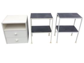 A pair of metal framed side tables, each with two rectangular platforms on column legs with pad