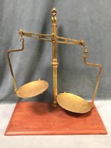 A set of brass balance scales by O Wolters London, the turned column with pointed finial