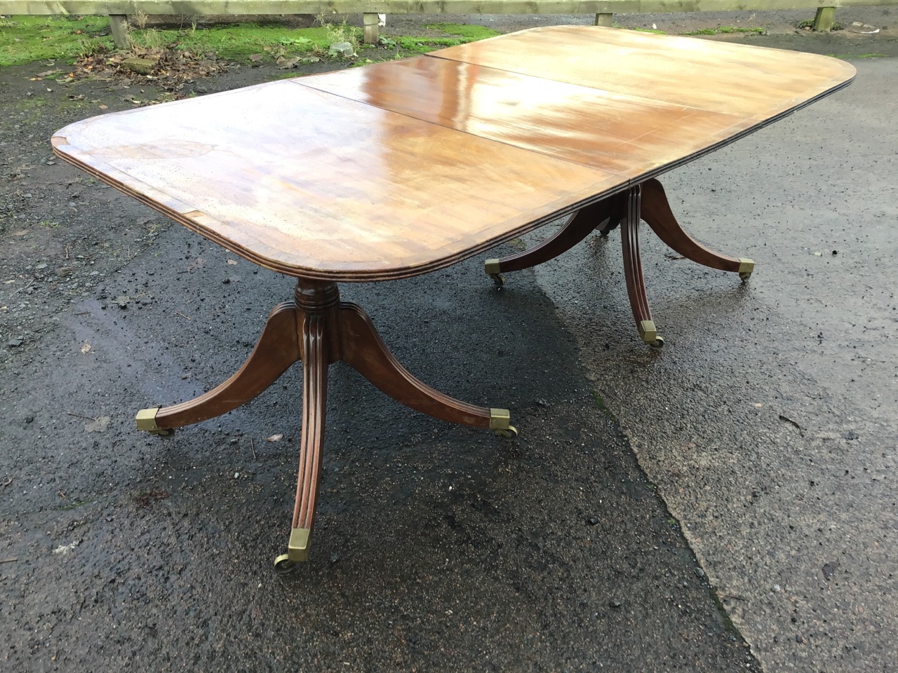 An Edwardian mahogany regency style twin pedestal dining table with spare leaf, the rounded - Image 2 of 3