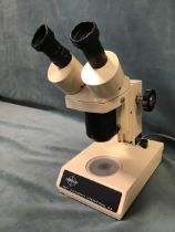 A Swift Instruments Stereo Eighty binocular microscope, with adjustable focus and illuminated base