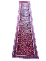 An oriental bokarra runner woven with field of hooked octagonal medallions on charcoal ground,