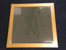 A contemporary square oak framed mirror with bevelled plate. (25.5in x 25.5in)