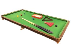 An oak framed tabletop snooker table, with two cues and a boxed set of Guinness Brothers balls