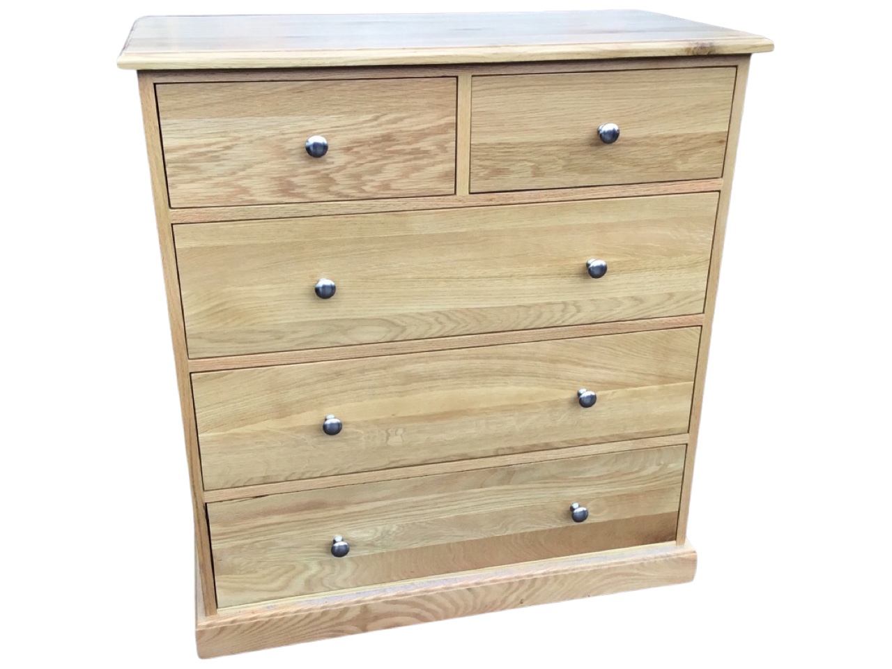 A contemporary oak chest of drawers, the rectangular top above two short and three long knobbed