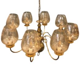 A large Dutch style brass chandelier with eight scrolled branches supporting candlelights and etched