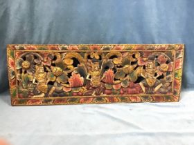 A rectangular pierced carved and painted panel with three stylised crowned figures on floral ground,