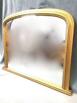 A Victorian style overmantle mirror in arched cushion moulded gilt frame on moulded plinth. (38in