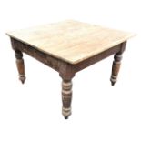 A Victorian pine kitchen table, the square top above a plain frieze fitted with a drawer with iron
