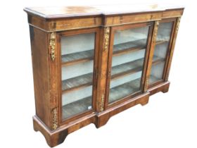 A Victorian walnut ormolu mounted breakfront side cabinet, the moulded top above a frieze inlaid