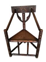 A nineteenth century mahogany turners chair with triangular seat framed by angled bobbin-turned arms