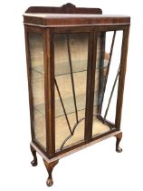 A deco mahogany display cabinet, the shaped back and rectangular caddy top above cloud & sunburst