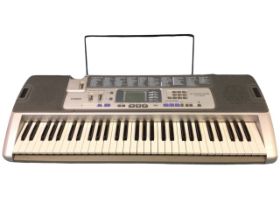 A Casio electronic keyboard with song bank, key lighting system, power cable, five octave