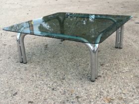 A 1970s square smoked glass coffee table, the rounded top on tubular chromed legs. (34in x 34in x